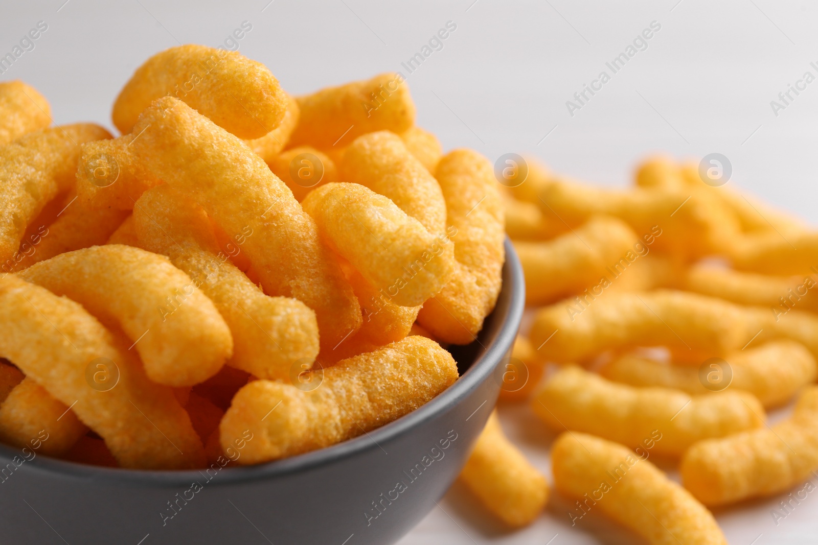 Photo of Bowl of tasty cheesy corn puffs, closeup. Space for text