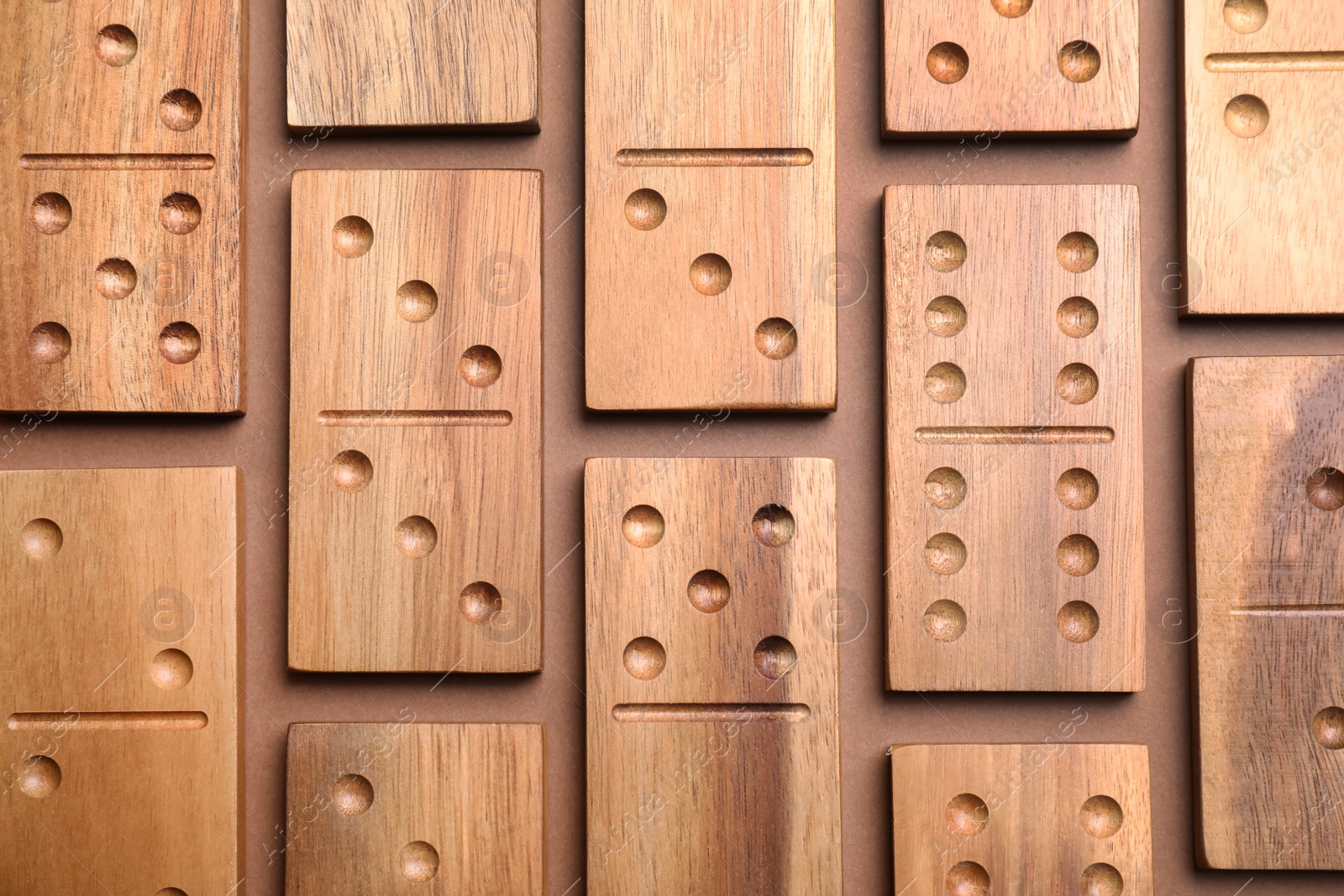 Photo of Set of wooden domino tiles on brown background, flat lay