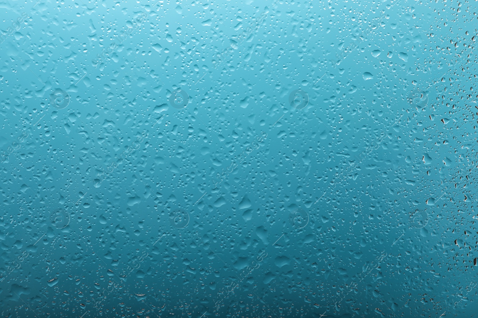 Photo of Clear water drops on light blue surface