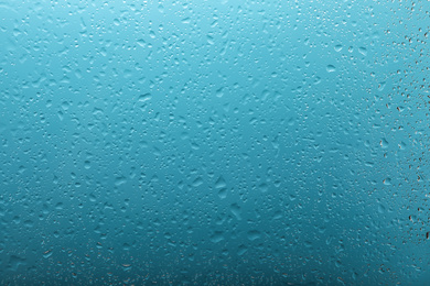 Clear water drops on light blue surface