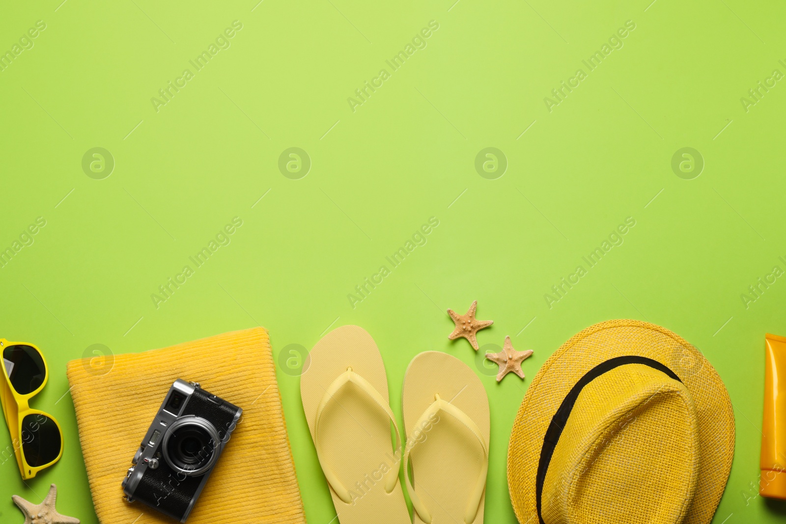 Photo of Flat lay composition with different beach objects on green background, space for text