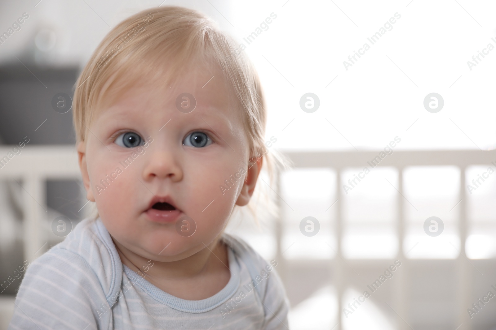Photo of Adorable little baby on blurred background, closeup