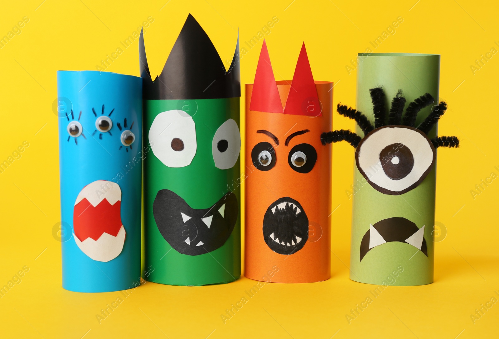 Photo of Funny monsters on yellow background. Halloween decoration