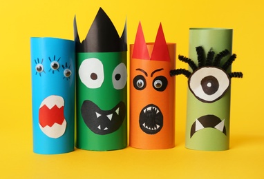 Photo of Funny monsters on yellow background. Halloween decoration