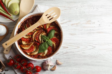 Delicious ratatouille and ingredients on white wooden table, flat lay. Space for text