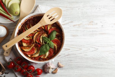 Photo of Delicious ratatouille and ingredients on white wooden table, flat lay. Space for text