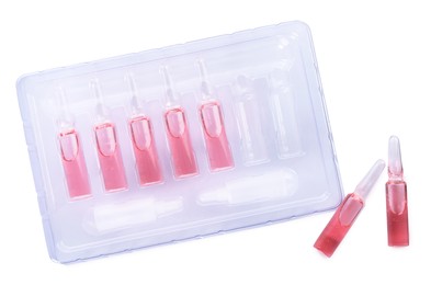 Photo of Tray with glass pharmaceutical ampoules on white background, top view