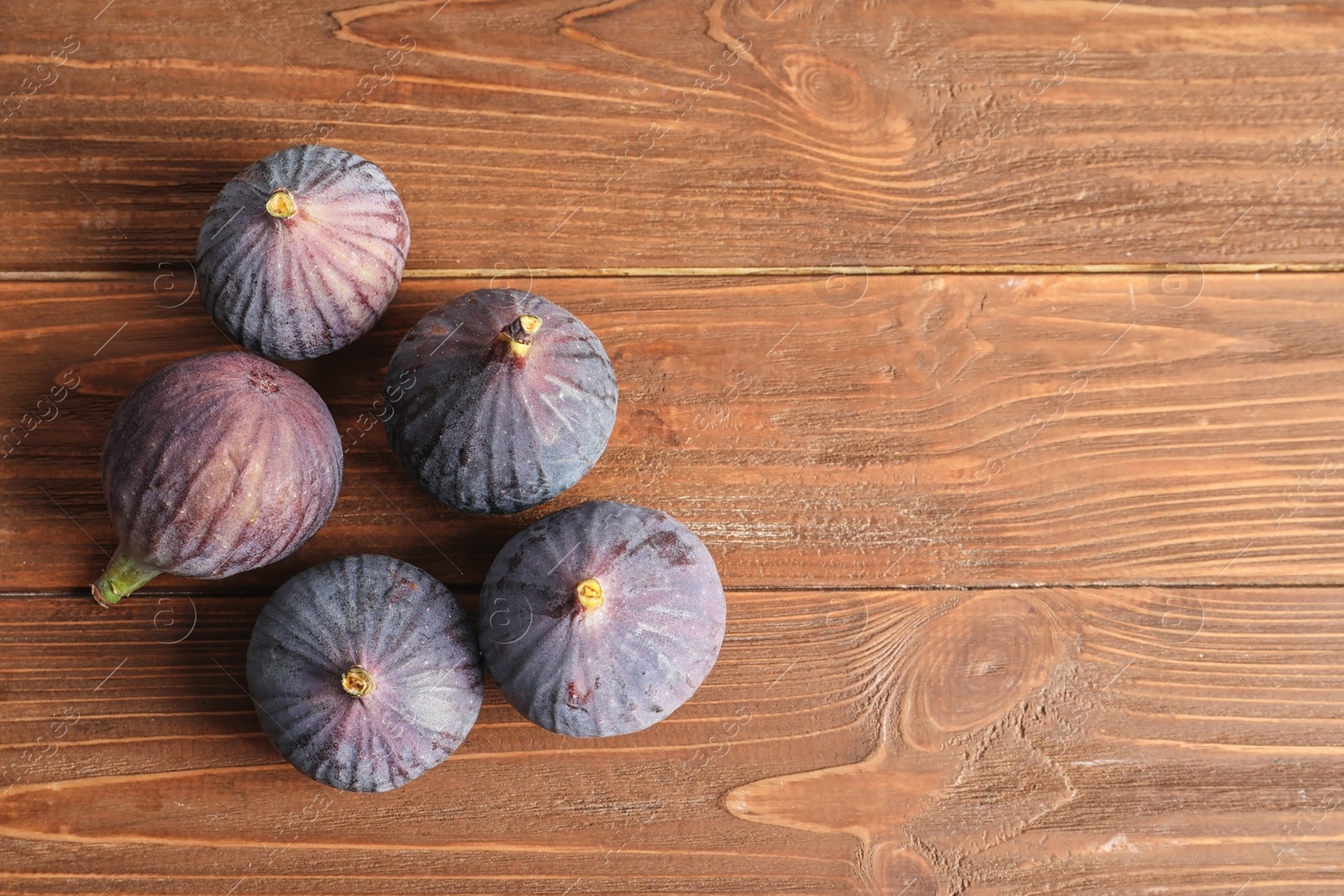 Photo of Ripe sweet figs on wooden background, top view. Space for text