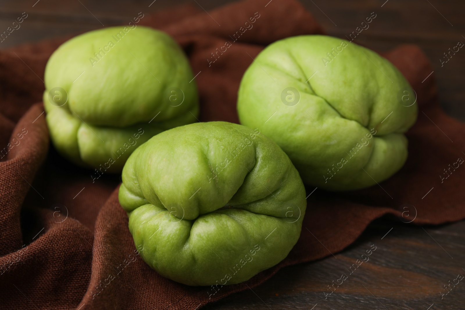 Photo of Fresh green chayote on wooden table, closeup