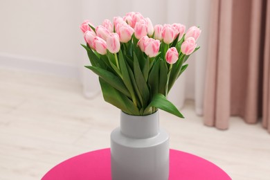 Beautiful bouquet of fresh pink tulips on table indoors