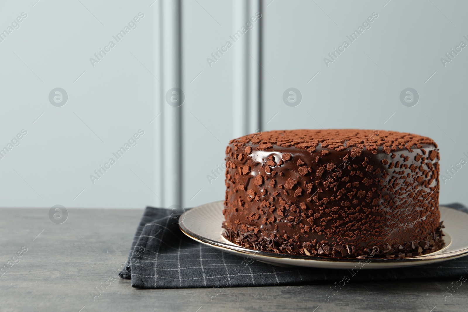 Photo of Delicious chocolate truffle cake on grey textured table, space for text