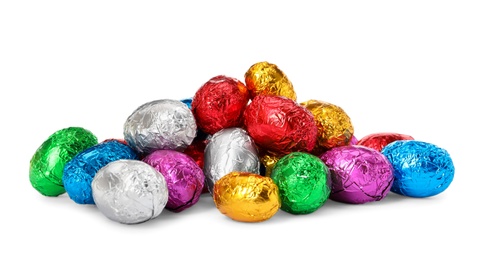 Photo of Many chocolate eggs wrapped in bright foil on white background