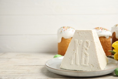 Traditional cottage cheese Easter paskha and eggs on white wooden table, space for text