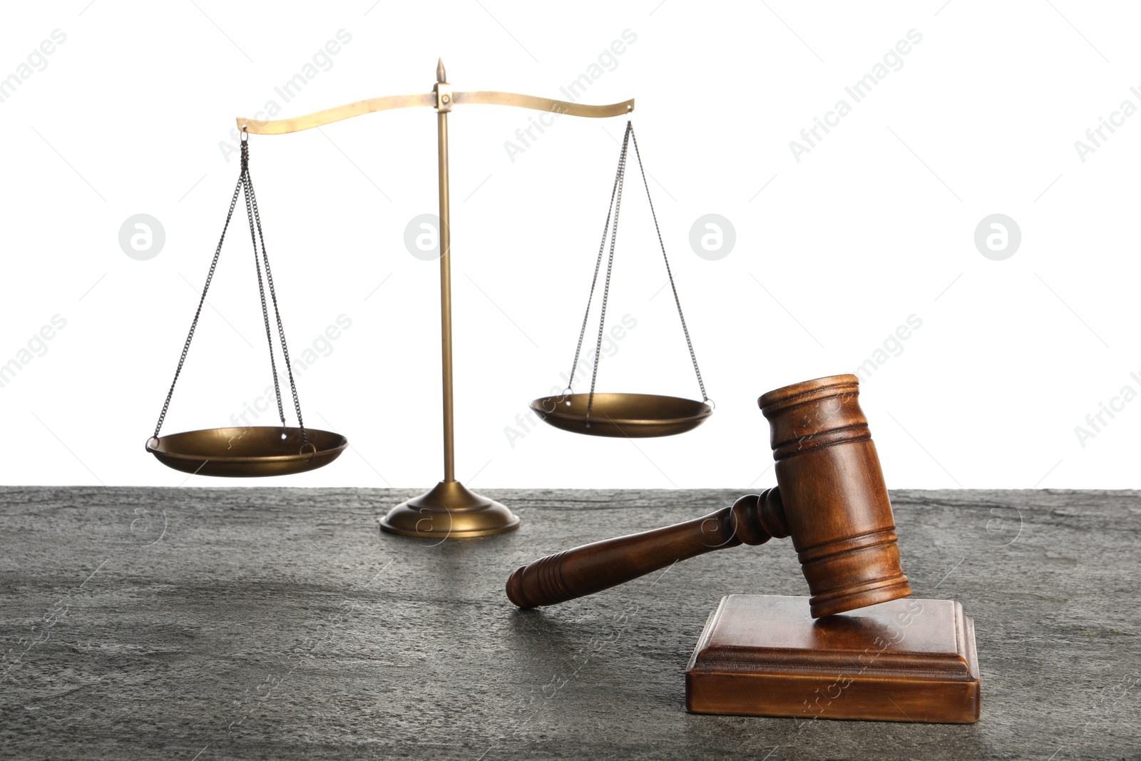 Photo of Law concept. Judge's mallet and scales of justice on dark grey table against white background