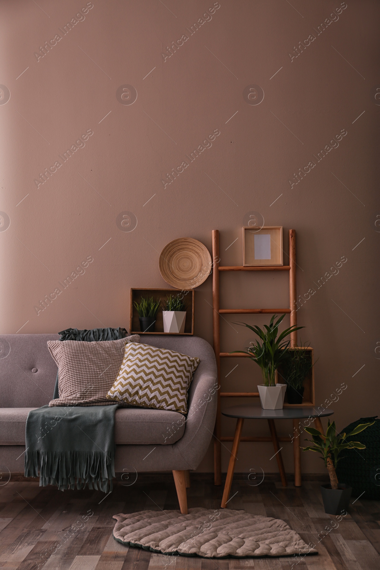 Photo of Modern eco style interior of living room with wooden crates and sofa near color wall