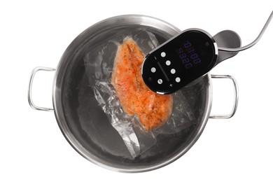 Photo of Thermal immersion circulator and vacuum packed meat in pot on white background, top view. Sous vide cooking