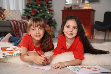 Photo of Little children writing letter to Santa at home. Christmas celebration