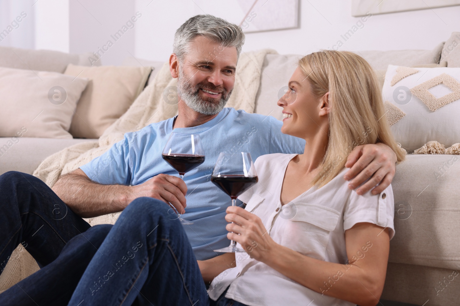 Photo of Happy affectionate couple with glasses of wine at home. Romantic date