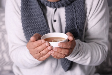 Photo of Man with cup of hot tea for cough, closeup