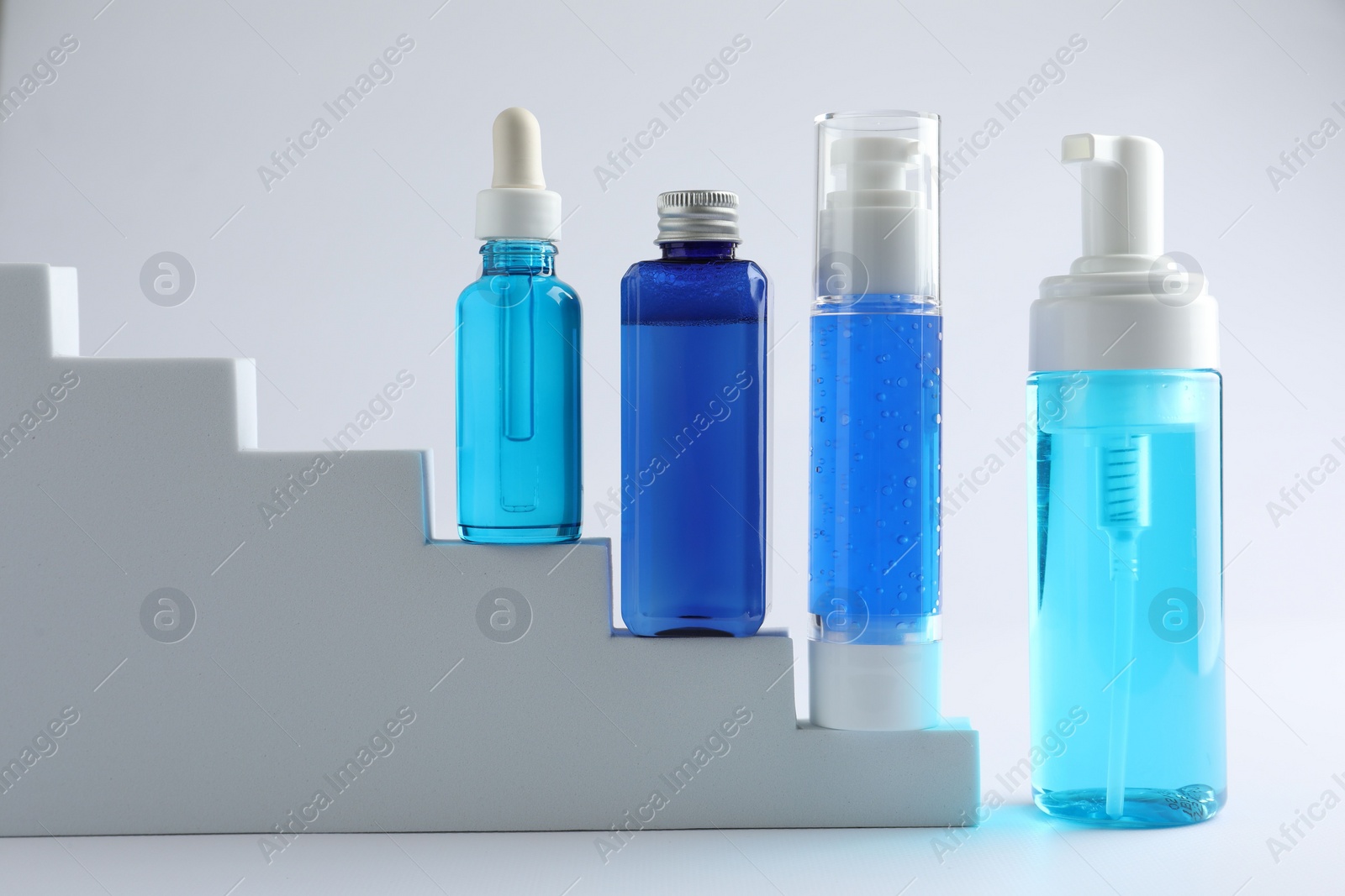 Photo of Set of luxury cosmetic products on stairs against white background