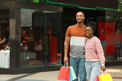 Photo of Family shopping. Happy couple with colorful bags in mall