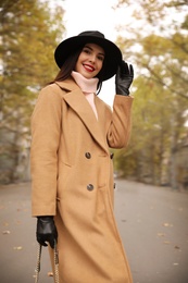 Photo of Young woman wearing stylish clothes on city street. Autumn look