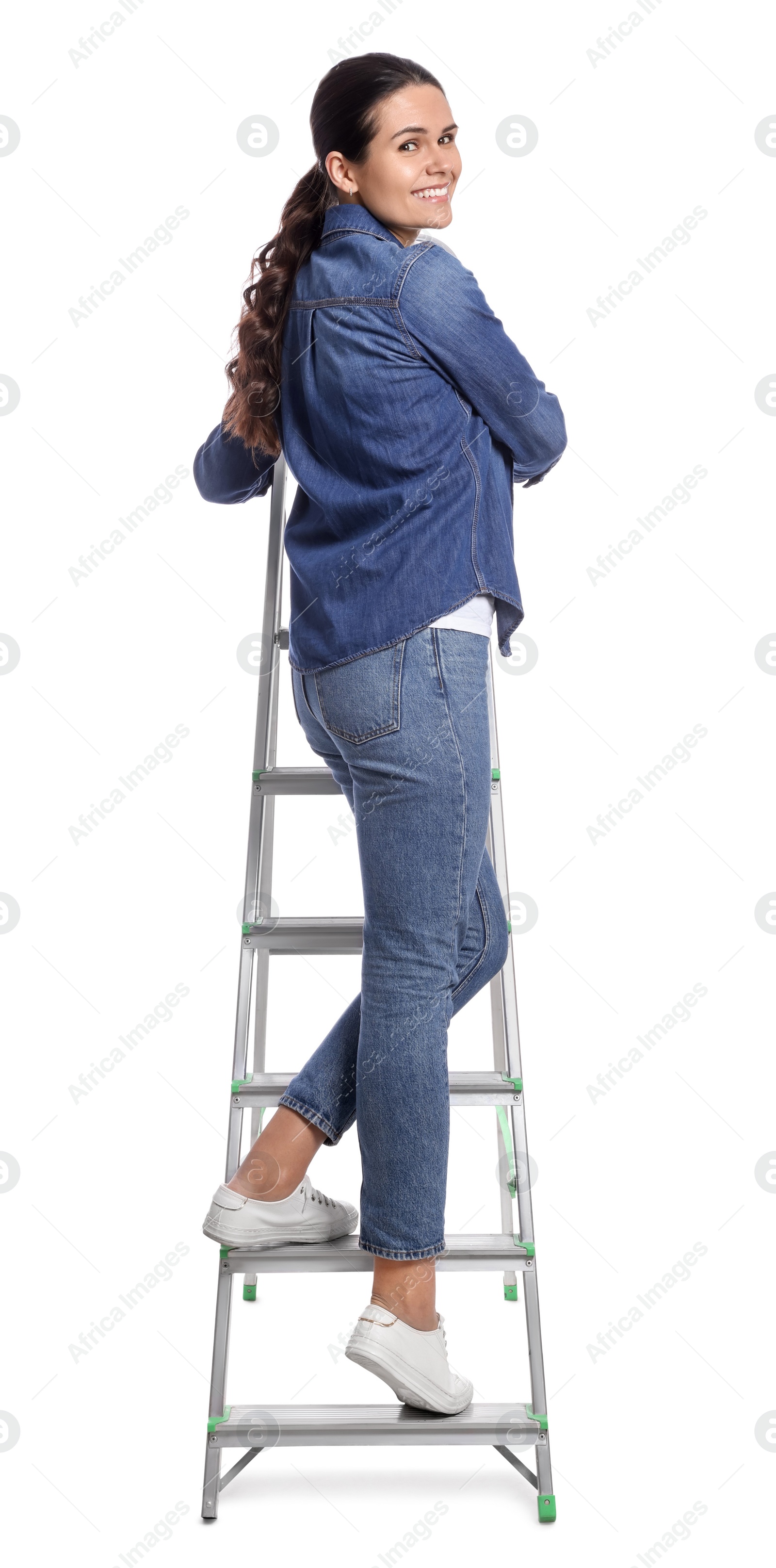 Photo of Young woman on metal ladder against white background