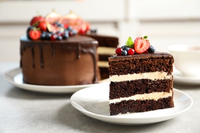 Photo of Plate with slice of chocolate sponge berry cake on grey table