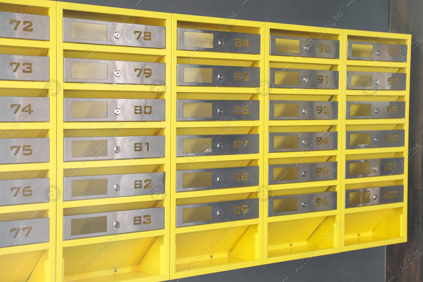 Photo of Many closed metal mailboxes with keyholes and numbers in post office