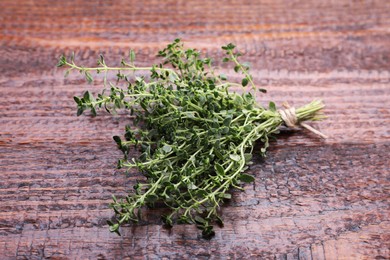 Photo of Bunch of aromatic thyme on wooden table. Fresh herb