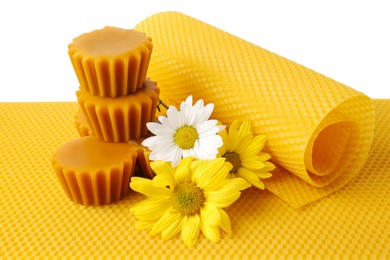 Photo of Natural beeswax cake blocks, flowers and sheets on white background