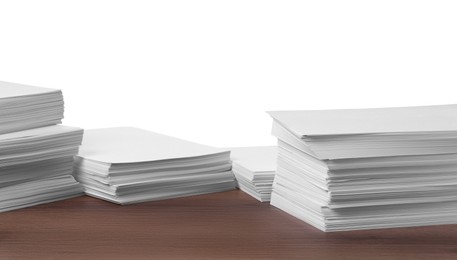 Photo of Stacks of paper sheets on wooden table against white background