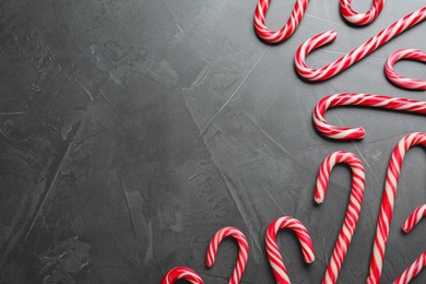 Photo of Sweet Christmas candy canes on grey background, flat lay. Space for text