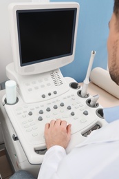 Photo of Sonographer operating modern ultrasound machine in clinic, closeup