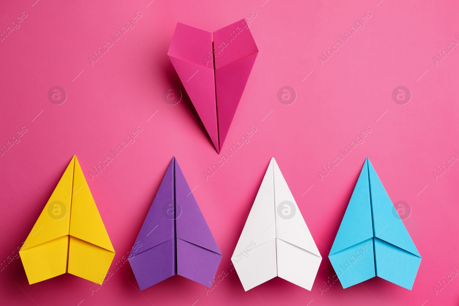 Photo of Flat lay composition with colorful paper planes on pink background