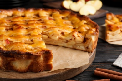 Traditional apple pie on black wooden table, closeup