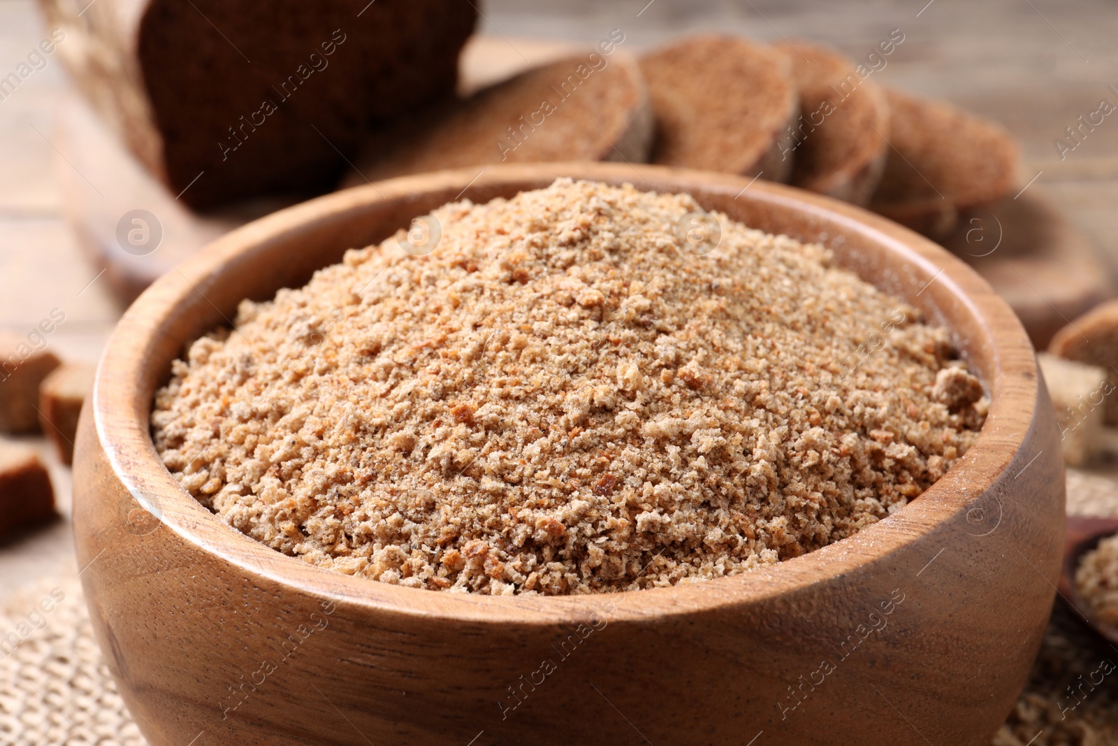 Photo of Fresh breadcrumbs in bowl on table, closeup