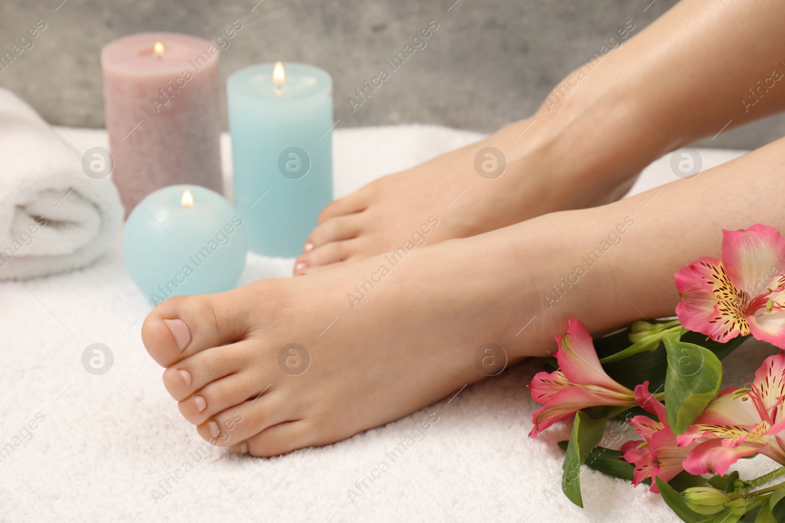 Photo of Woman with neat toenails after pedicure procedure on white terry towel, closeup