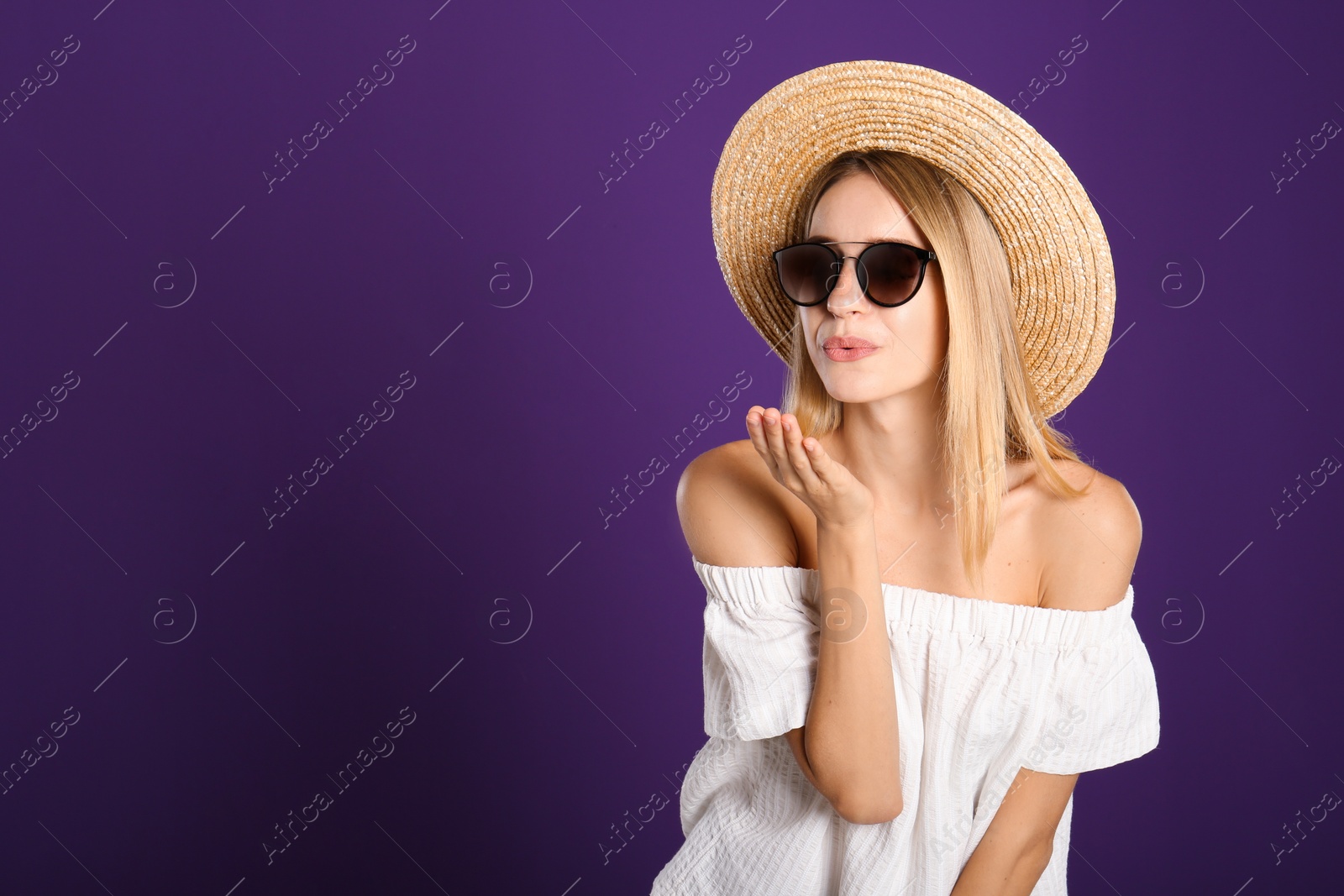 Photo of Beautiful woman in stylish sunglasses on purple background. Space for text