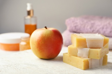 Handmade soap bars and apple on table
