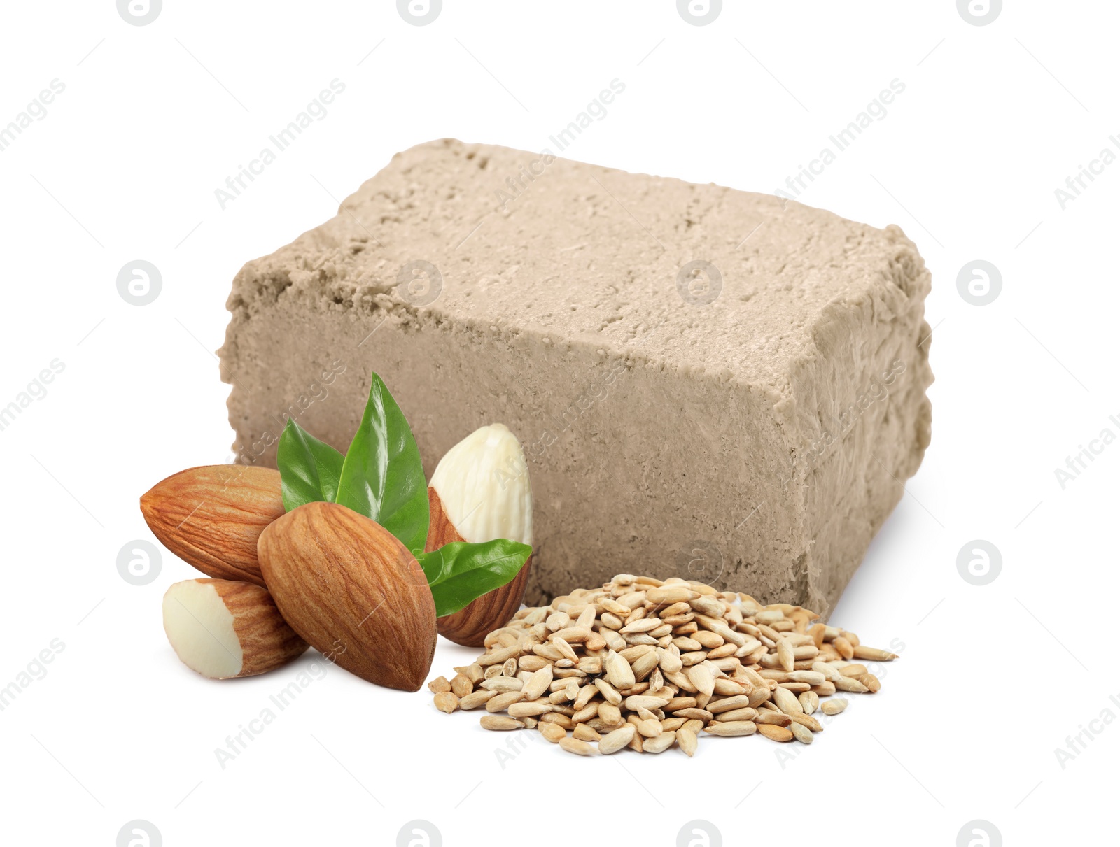 Image of Tasty halva, peeled sunflower seeds, almonds and green leaves isolated on white