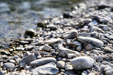 River coast with stones and pebbles on sunny day