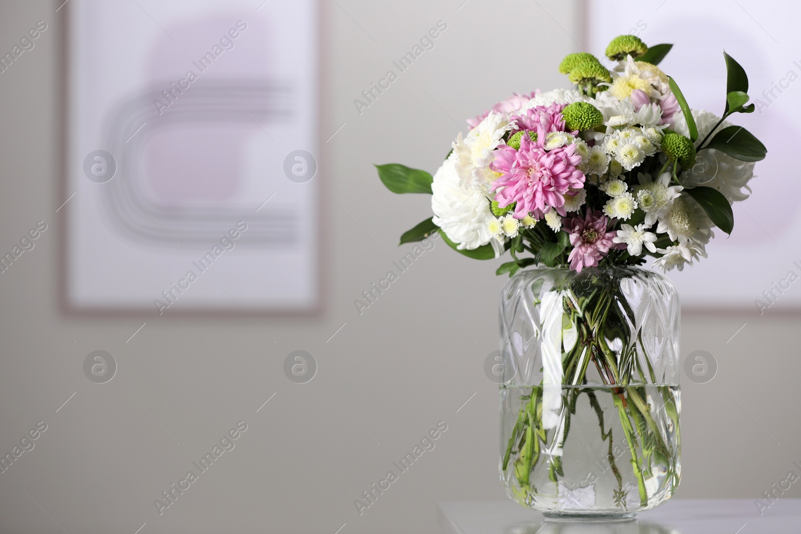 Photo of Bouquet of beautiful chrysanthemum flowers on table in room, space for text