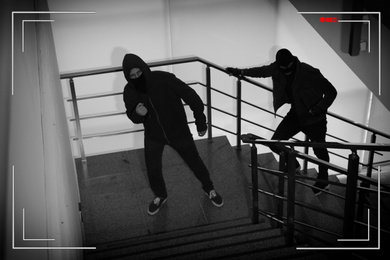 Criminals in masks on stairs indoors, view through CCTV camera