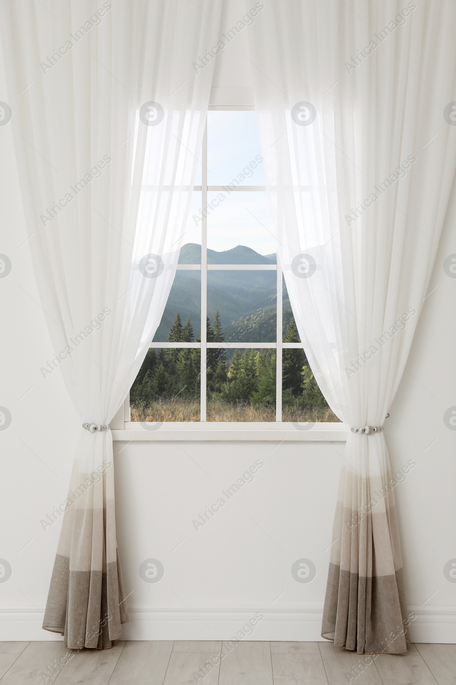 Image of Beautiful view of mountain landscape through window with curtains