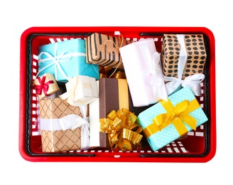 Shopping basket full of gift boxes on white background, top view