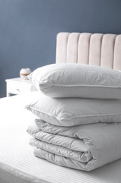 Soft folded blanket and pillows on bed indoors