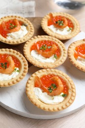 Delicious canapes with shrimps, red caviar and cream cheese on light table