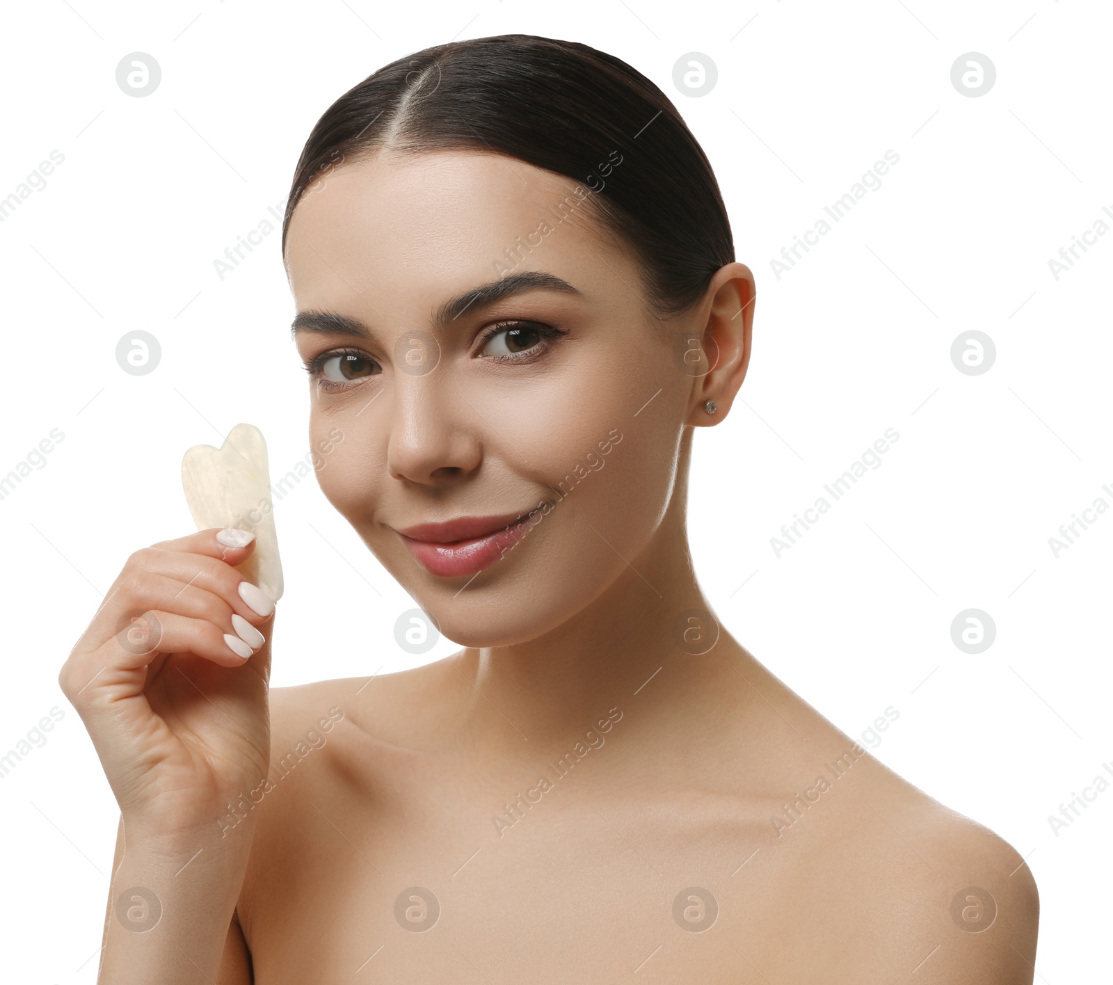 Photo of Beautiful young woman doing facial massage with gua sha tool on white background