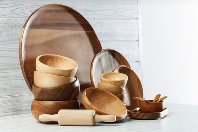 Set of clean wooden dishware and utensils on table